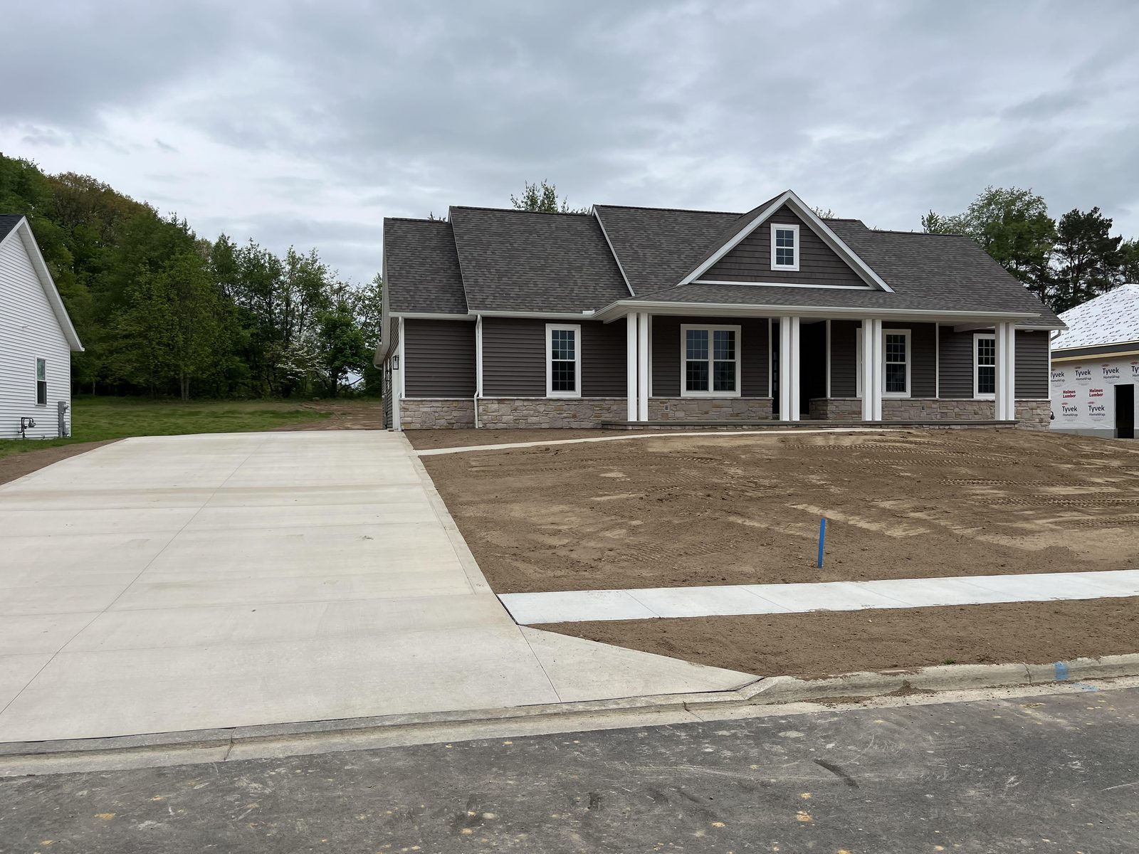 Brown craftsman ranch with white columns and wraparound porch