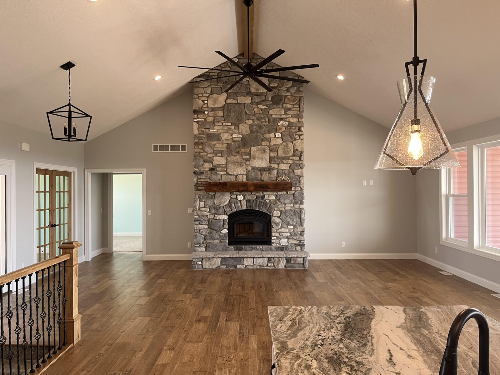 Great room with full floor-to-ceiling stone fireplace, reclaimed wood mantle, and vaulted tongue-and-groove ceiling
